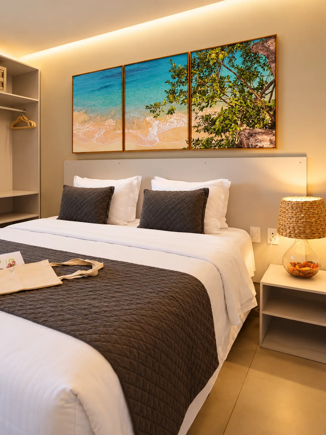 Cabeceira, quadros e cama do quarto Deluxe