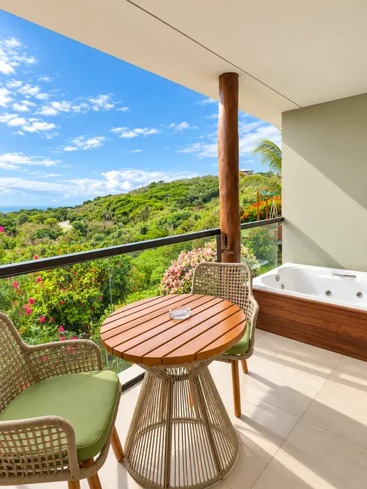 Varanda do quarto Deluxe com hidromassagem e paisagem tropical